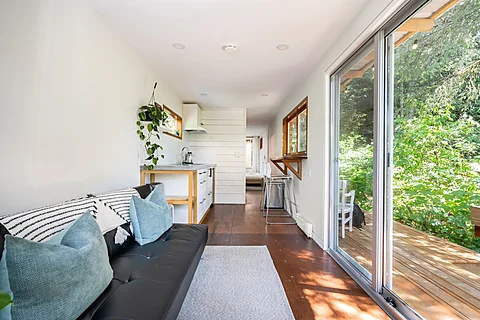 Bright cabin living space with sliding doors to the forest, Sooke real estate photography