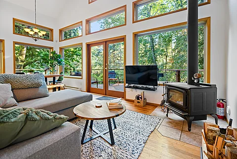 Glass-walled living room surrounded by forest, Kelowna real estate photography