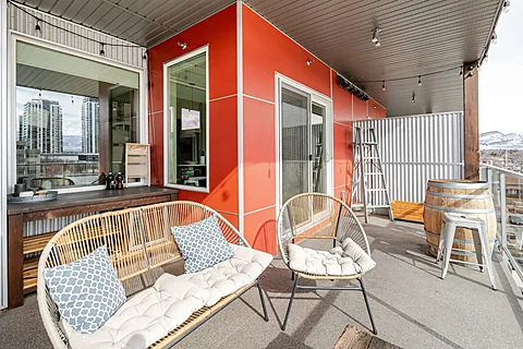 Condo living room with a rust accent wall and balcony access, Kelowna real estate photography