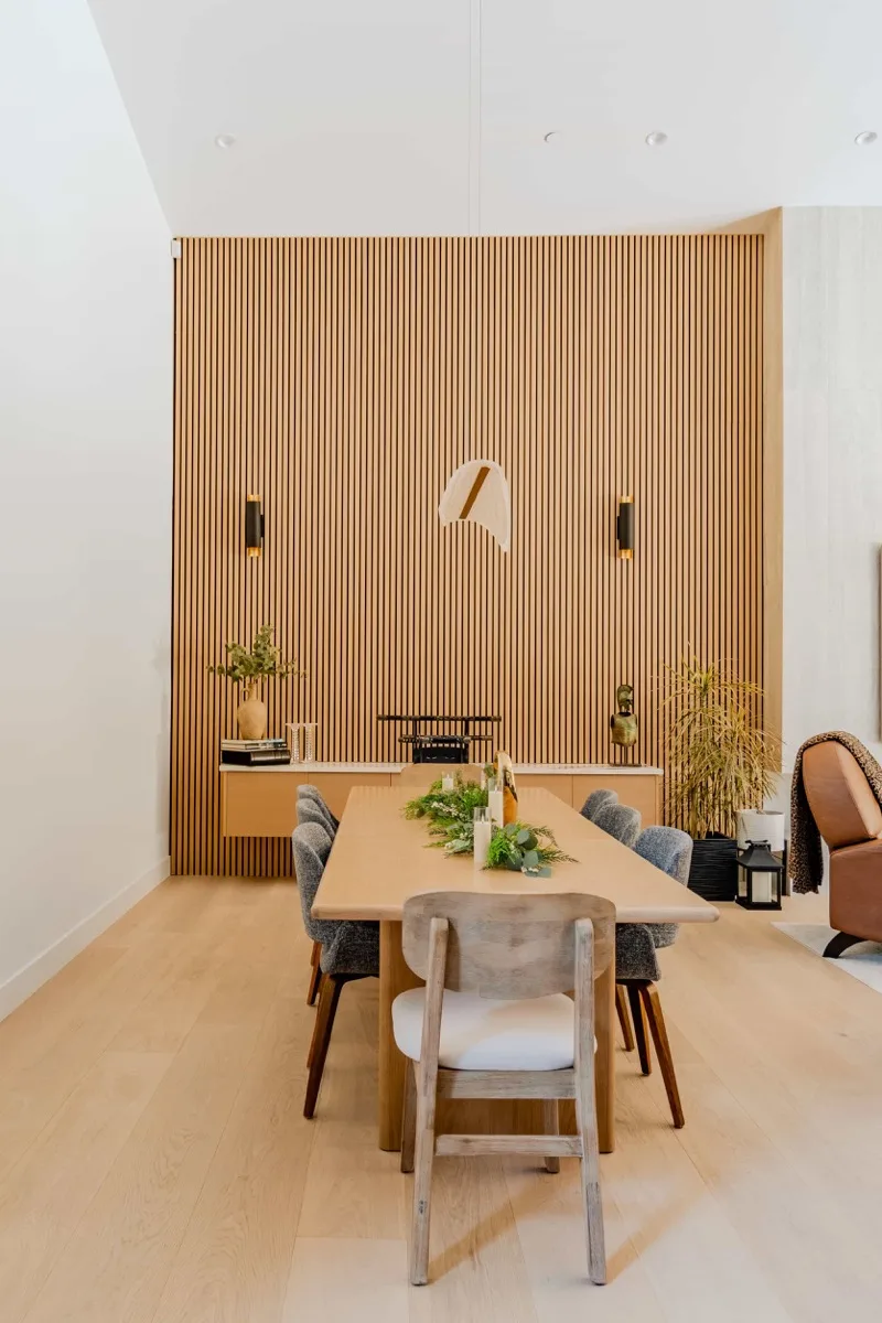 Dining room with wood slat accent wall and pendant lights