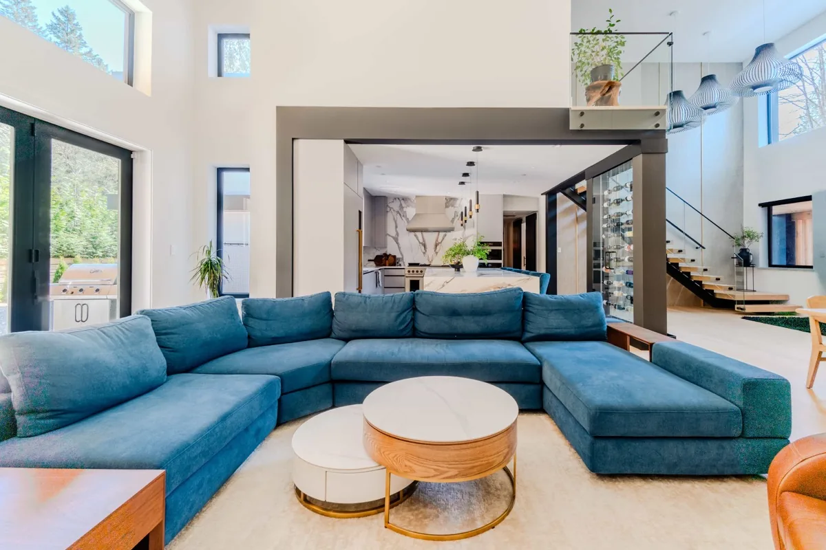 Luxury open-plan living room with blue sectional sofa and wine wall